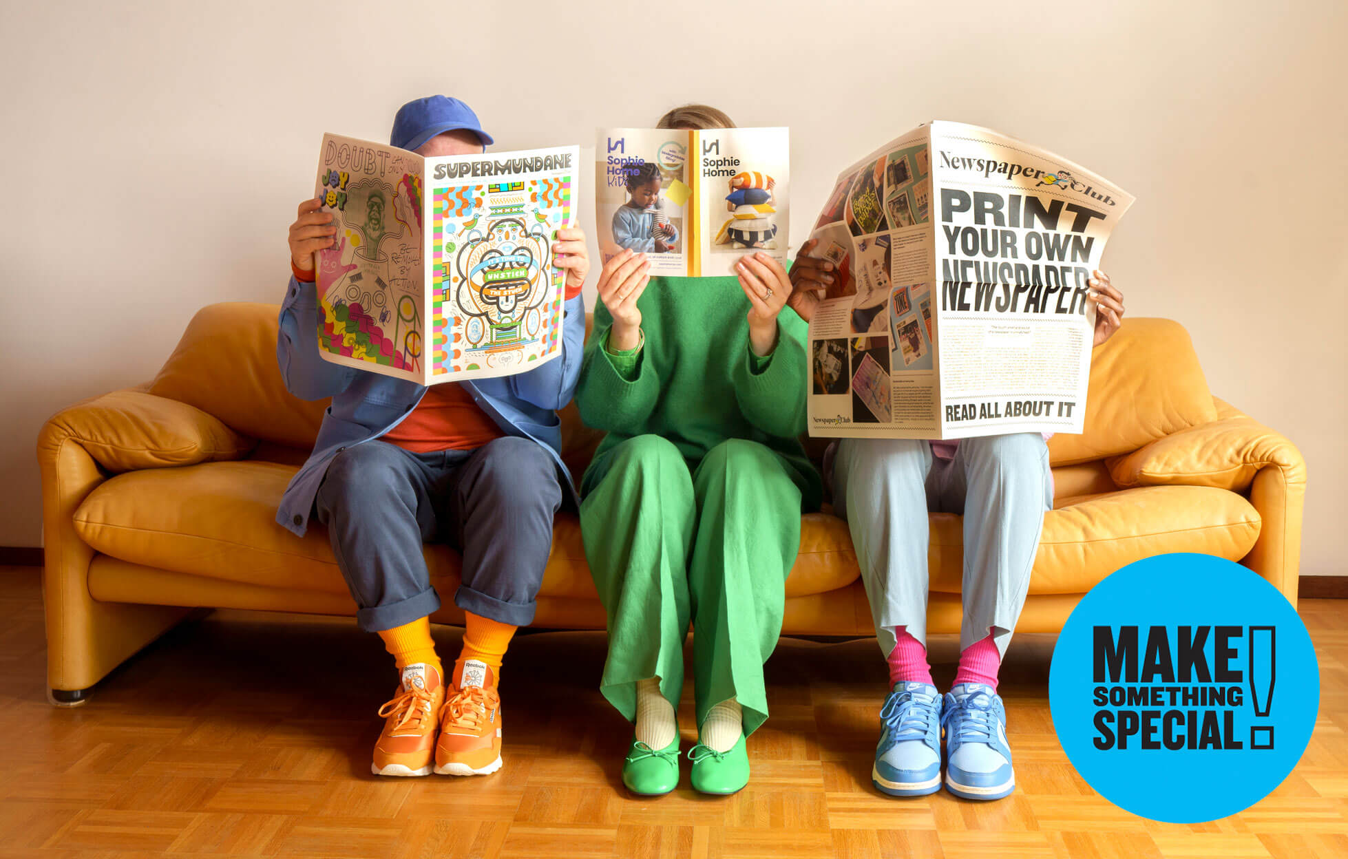 Three people on a couch reading custom-printed newspapers.