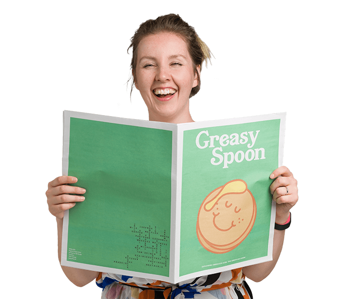 Woman holding tabloid-sized newspaper.